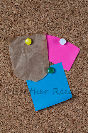 Three colorful blank notes on corkboard
