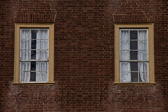 Two rectangular windows on red brick wall.
