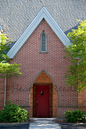 Cathedral entryway with a red door.