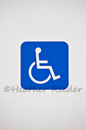 Handicap accessibility sign surrounded by white background.