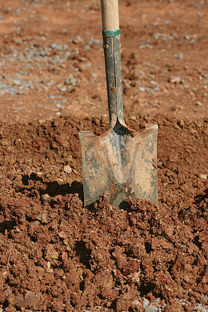 Small shovel standing in dirt pile.
